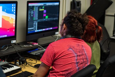 Students at Champlain work in tandem at a computer during a summer audio engineering class