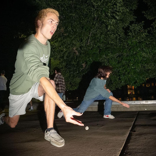 Jacob Dwyer is kneeling while throwing a Coin in the Dark during an underground meeting of the Champlain Coin Racers