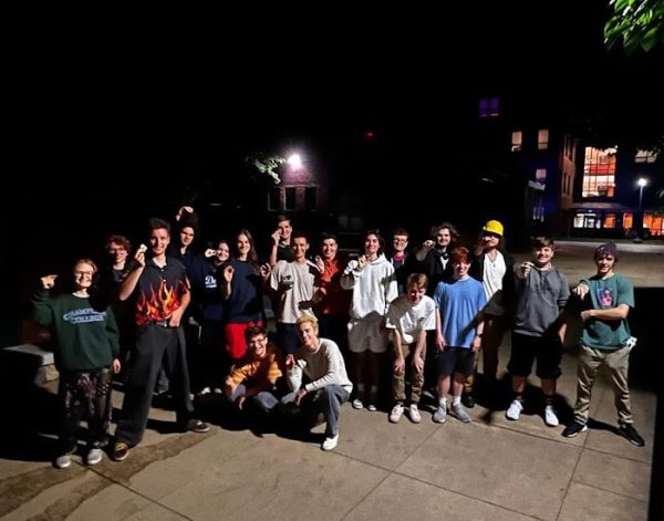 A group of approx. 20 peopleholding their coins and smiling.