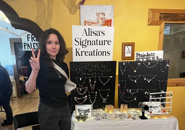 Alisa Stands in front of her Signature Kreations display table at a student business event.